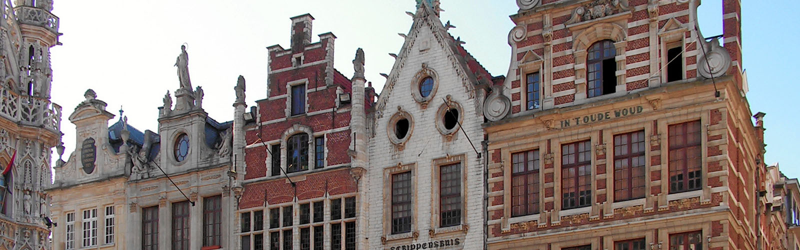 Old buildings scrunched together. The tops of the buildings are triangular.